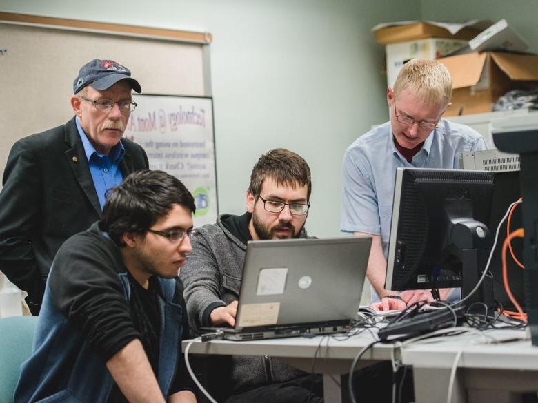 Penn State Mont Alto staff members help students at a computer workstation