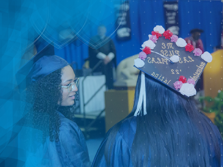 photo of commencement with female students standing in line to receive diploma